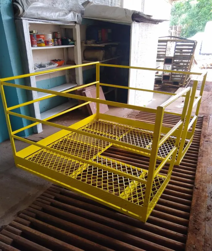 Plataforma com piso em grade e guarda-corpo amarelo