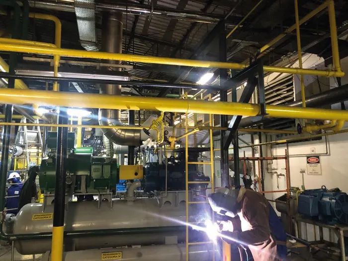 Soldagem de tubulação em sala de máquinas de refrigeração por amônia